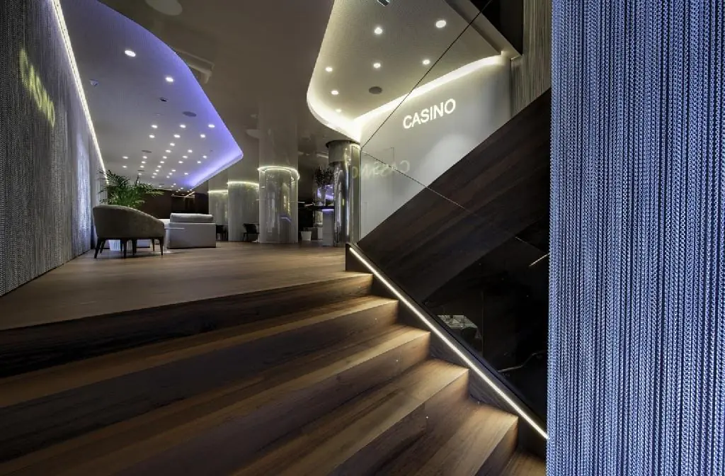 Escalera de madera del Hotel Rincón de Pepe en Murcia, con peldaños de nogal e iluminación LED integrada en el pasamanos