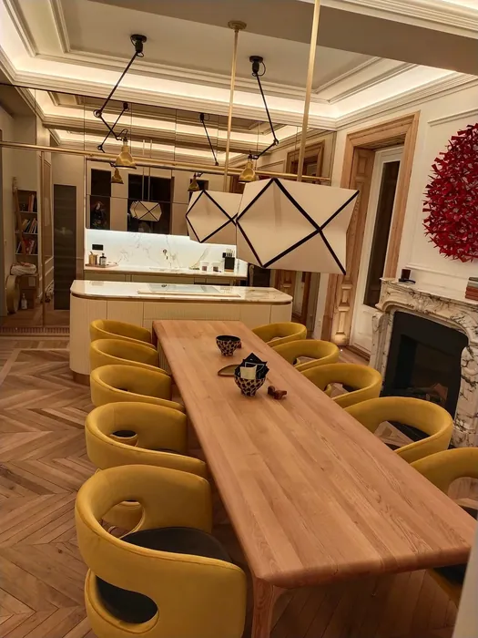 Cocina abierta al comedor, con mesa de roble macizo y paneles de espejo bronce al fondo